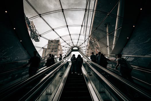 People ascending an escalator in a glass tunnel, New York City.