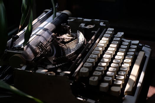 A classic vintage typewriter in sunlight with deep shadows, evoking nostalgia and history.