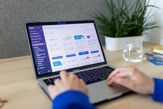 Close-up of hands on a laptop browsing an e-commerce site in a modern office.