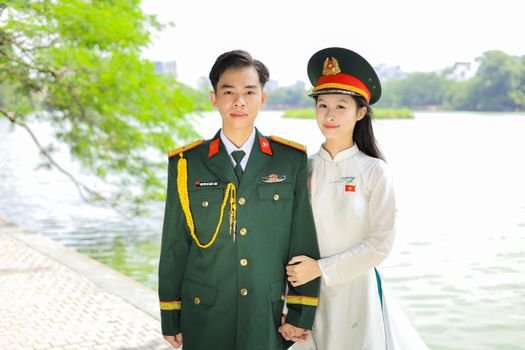 Portrait of Vietnamese officers in uniform standing by a lakeside, showcasing national pride.