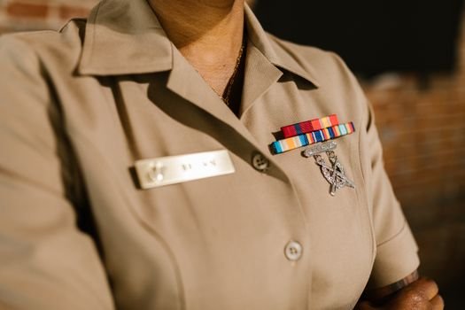 A detailed shot of a military uniform displaying medals and identification badges representing achievement and honor.
