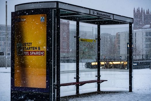 Desolate city bus stop in snowy winter at Museuminsel Berlin, perfect for public transport themes.