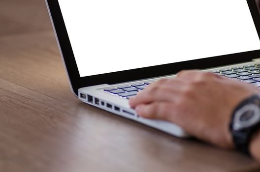 Close-up of a hand using a laptop with a blank screen, ideal for adding custom content.