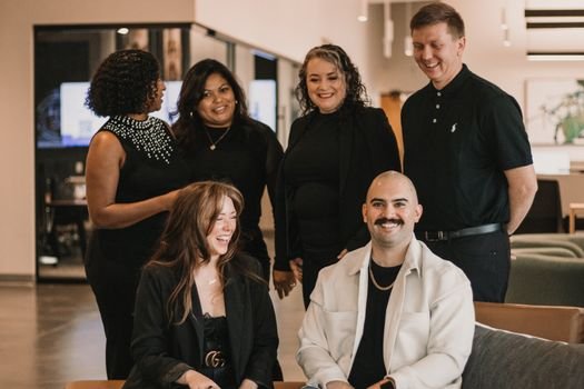 Diverse real estate team engaged in conversation in a modern office setting.