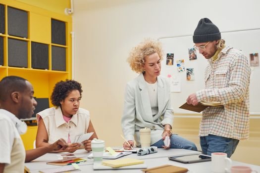 Diverse team brainstorming in a modern office setting, discussing ideas and teamwork.